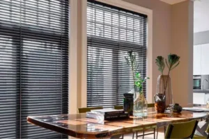 Imatge de persianes d’alumini instal·lades en una finestra, que ofereixen durabilitat i protecció contra el sol.