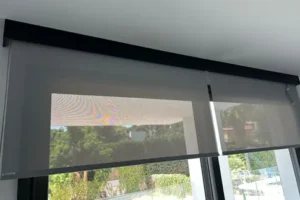 Cortina enrotllable blanca que s’ajusta fàcilment per controlar la llum i la privadesa