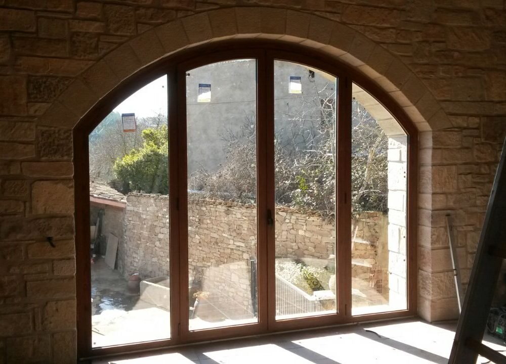 Finestra d'un client particular, ha incorporat una balconera amb forma